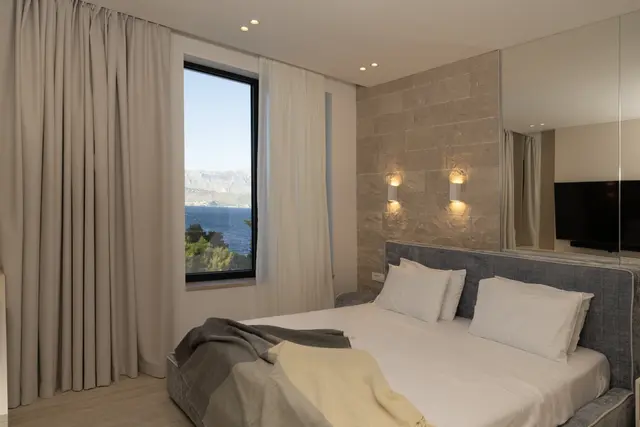 Bedroom with sea-view window and warm wall lighting