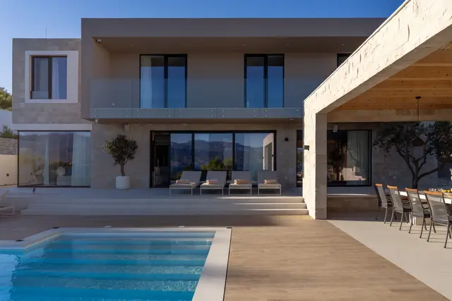Villa Danica seen from the pool deck, stone and glass