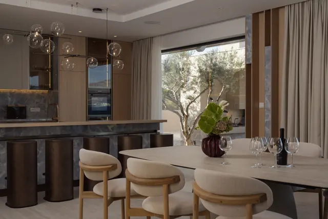 The indoor dining table beside the kitchen, olive tree outside