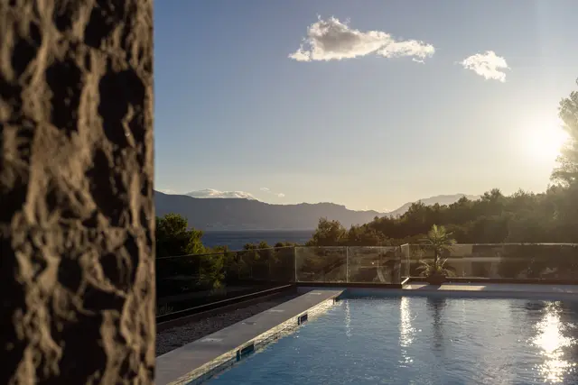 Late sun over the pool, stone wall in the foreground
